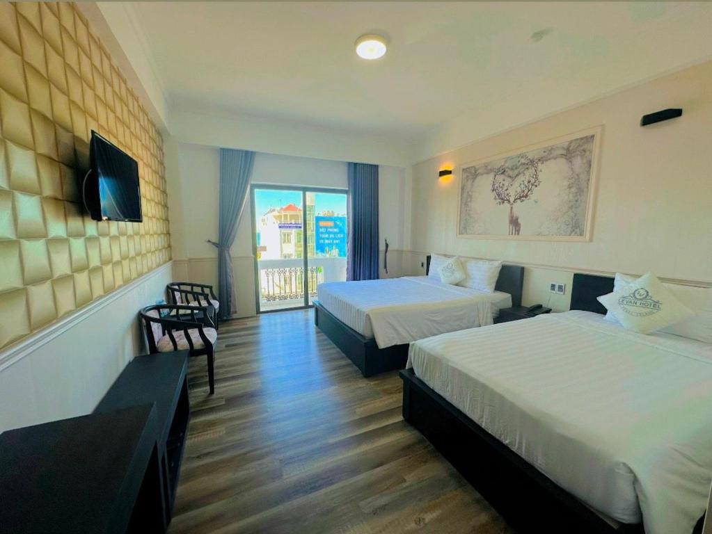 um quarto de hotel com duas camas e uma varanda em Levan Hotel em Phu Quoc