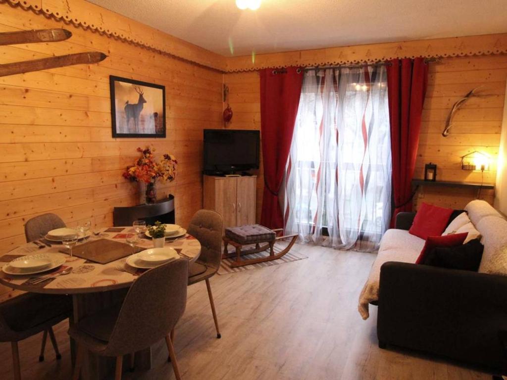 a living room with a table and a couch at Appartement Bagnères-de-Luchon, 2 pièces, 6 personnes - FR-1-313-218 in Luchon