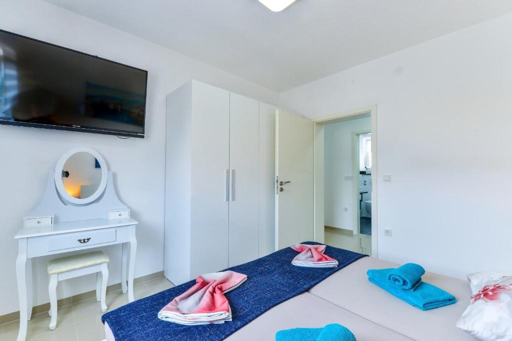 Televízia a/alebo spoločenská miestnosť v ubytovaní Apartments Olujic