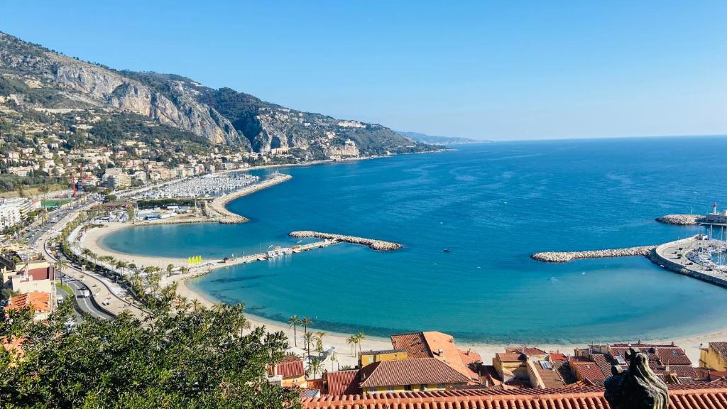 - une vue sur une plage avec des bateaux dans l'eau dans l'établissement Cozy Lemon Menton, à Menton