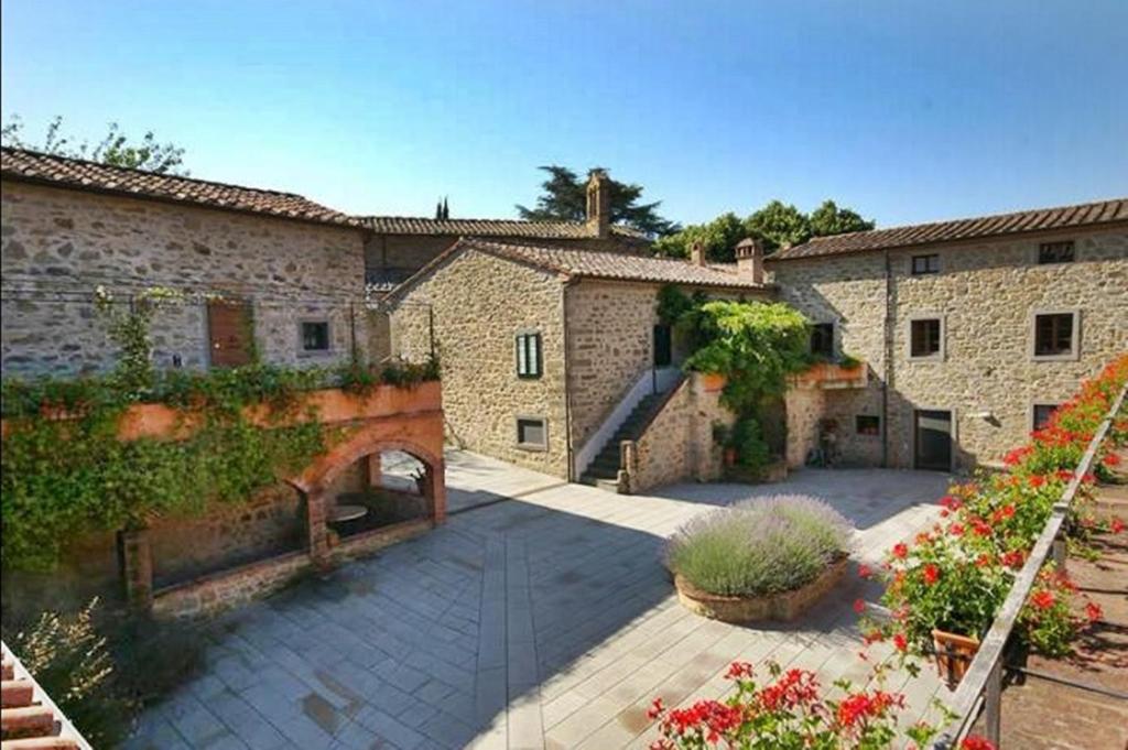 a courtyard of an old stone building with flowers at Antica Cortona in Cortona