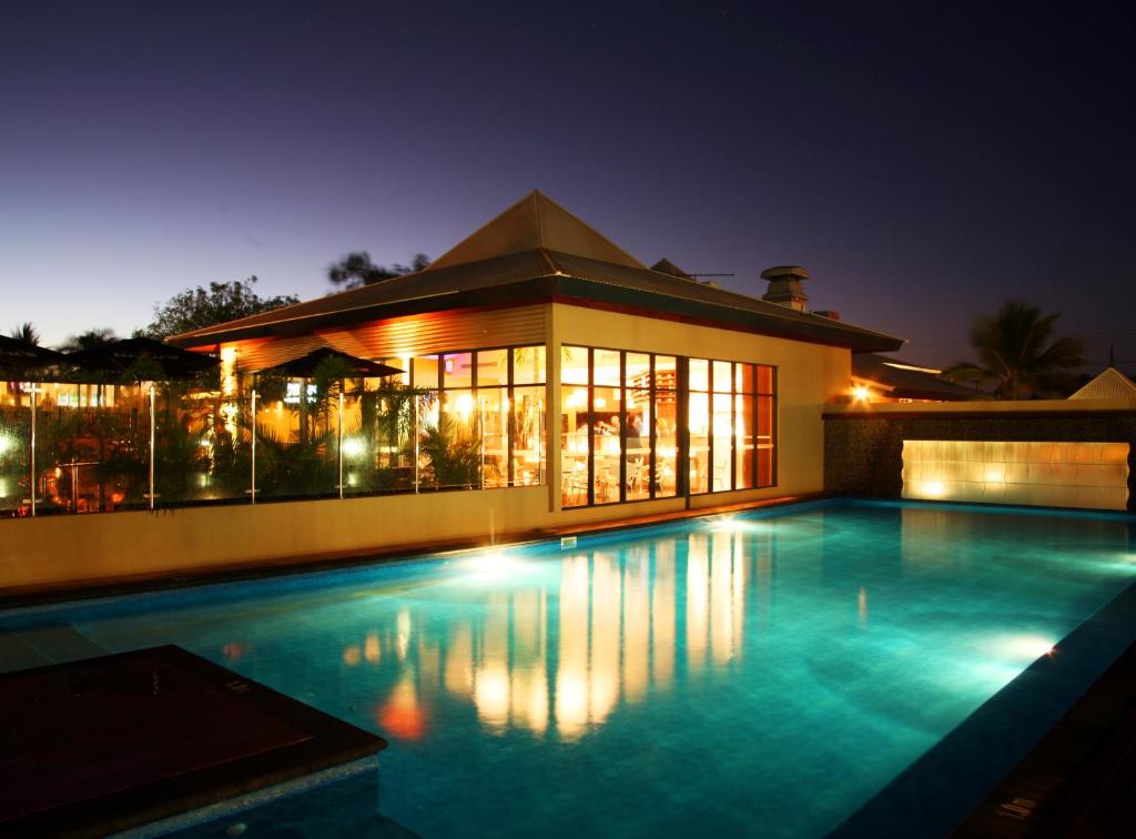 a swimming pool in front of a house at night at Beaches of Broome in Broome
