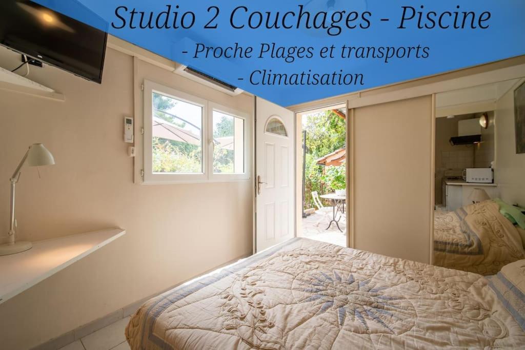 1 dormitorio con cama y ventana en Le figuier air-conditioned studio and swimmin, en Marsella