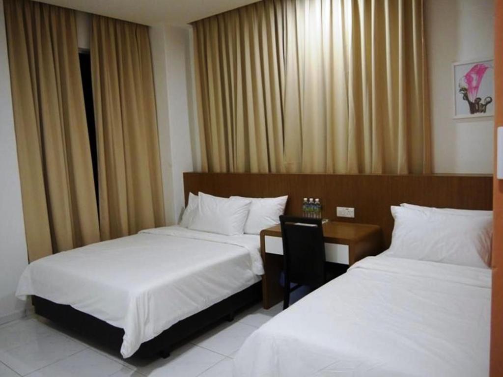 Postel nebo postele na pokoji v ubytování Hotel Wawasan