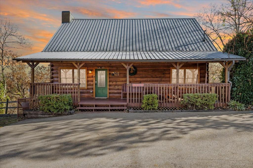 a log cabin with a porch and a green door at Five-Bedroom House in Sevierville
