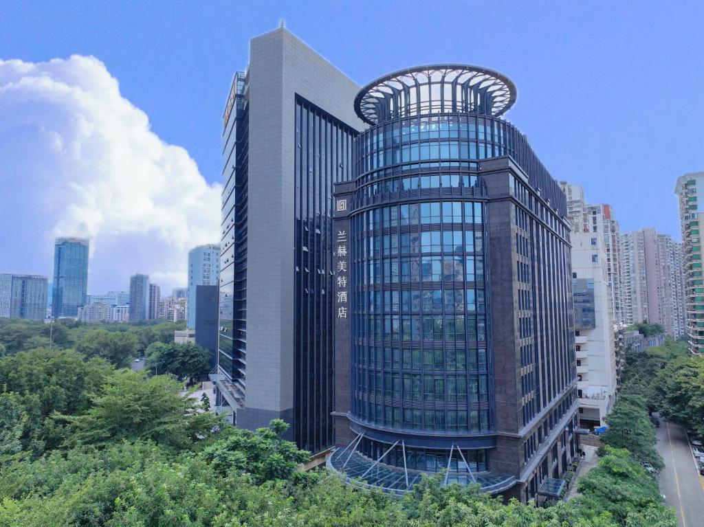a tall glass building with a spiral in a city at Shenzhen Nanshan L'Hermitage in Shenzhen