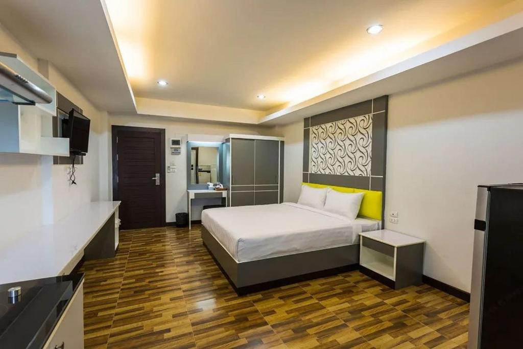 a hotel room with a bed and a kitchen at The Ring Residence in Hat Yai