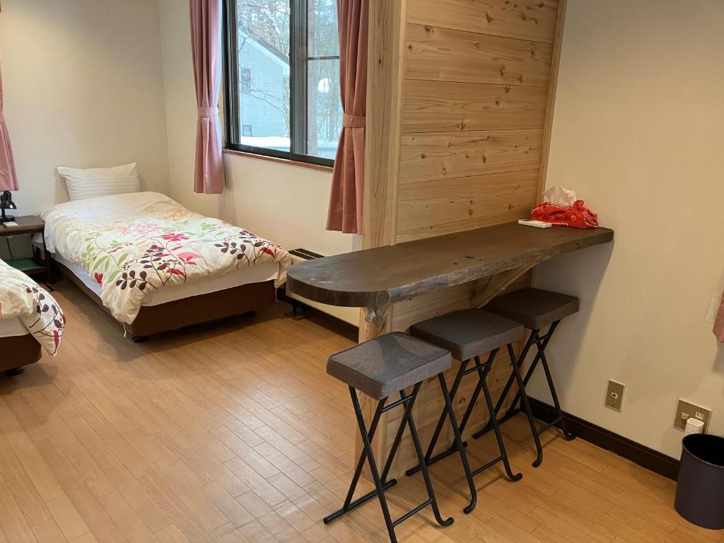 a room with a table and a bed and a desk at Piremon in Hakuba