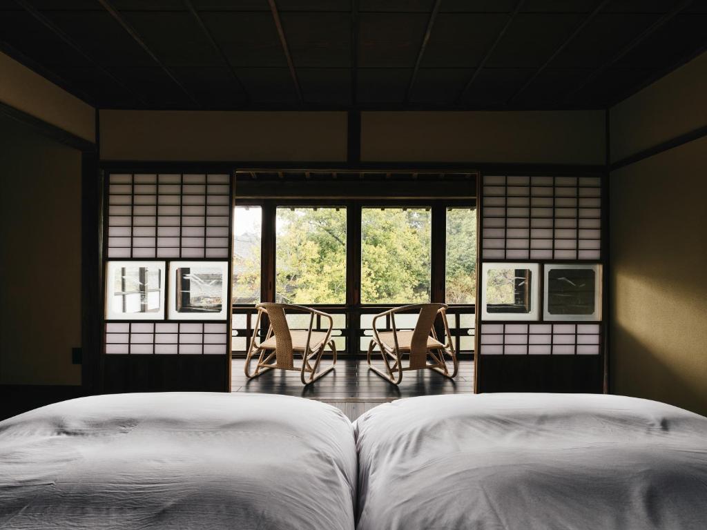 two beds in a room with a table and chairs at Minamo in Ukiha