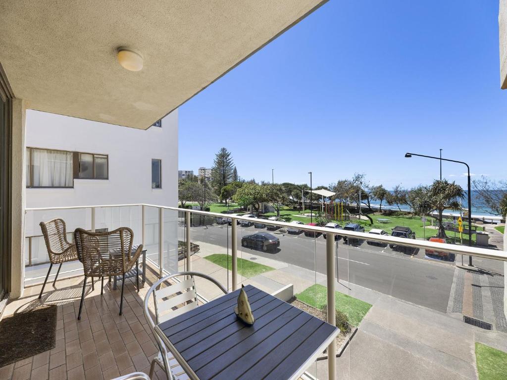 d'un balcon avec une table et des chaises offrant une vue sur la rue. dans l'établissement Jamarkos Unit 4 Kings Beach QLD, à Caloundra