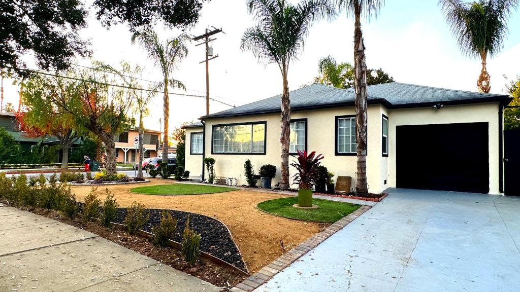 una casa con garaje y palmeras en Spacious, Private, Modern 4 Bedroom House Plus Game Room, en Glendale