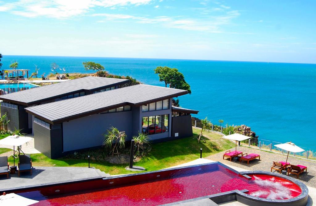 a house with a swimming pool next to the ocean at The Houben - Adult Only in Ko Lanta