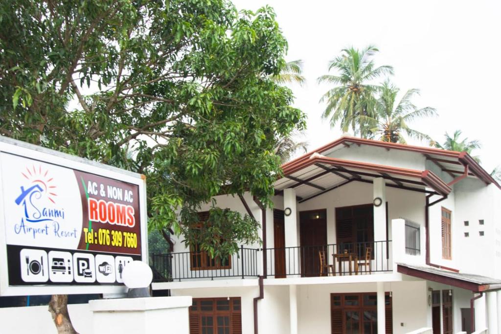 a house with a balcony and a sign in front of it at Sanmi Airport Resort in Katunayaka