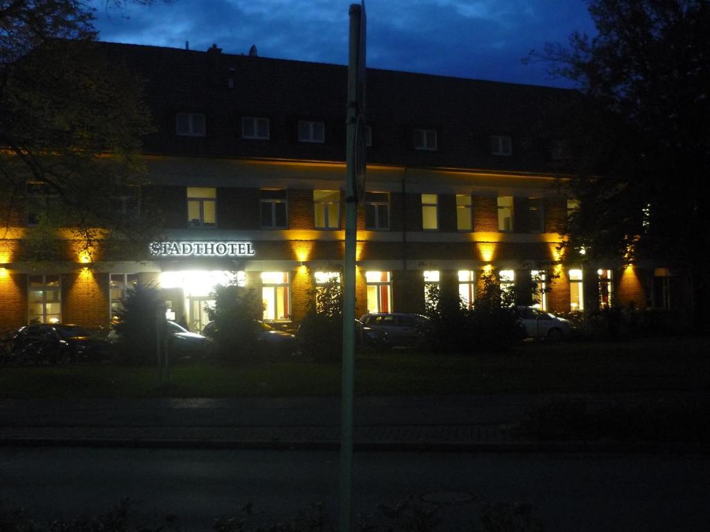 a building with a sign that reads scientologist at night at Stadthotel Bocholt in Bocholt