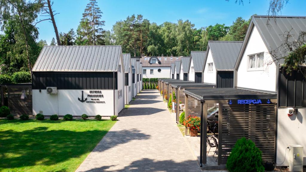 a row of white buildings in a yard at Kotwica-Pobierowo Bukowa 1 in Pobierowo