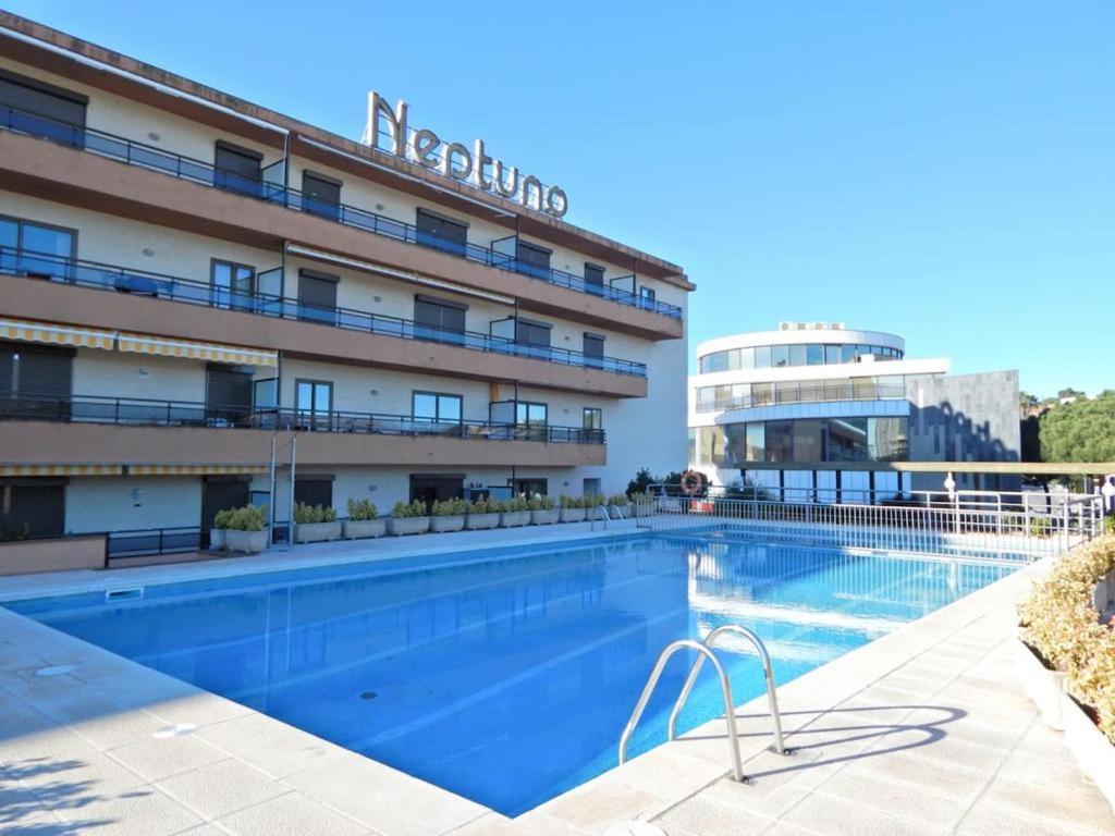 a swimming pool in front of a hotel at Apartamento alto standing con piscina privada, aire acondicionado y wifi in Platja d'Aro