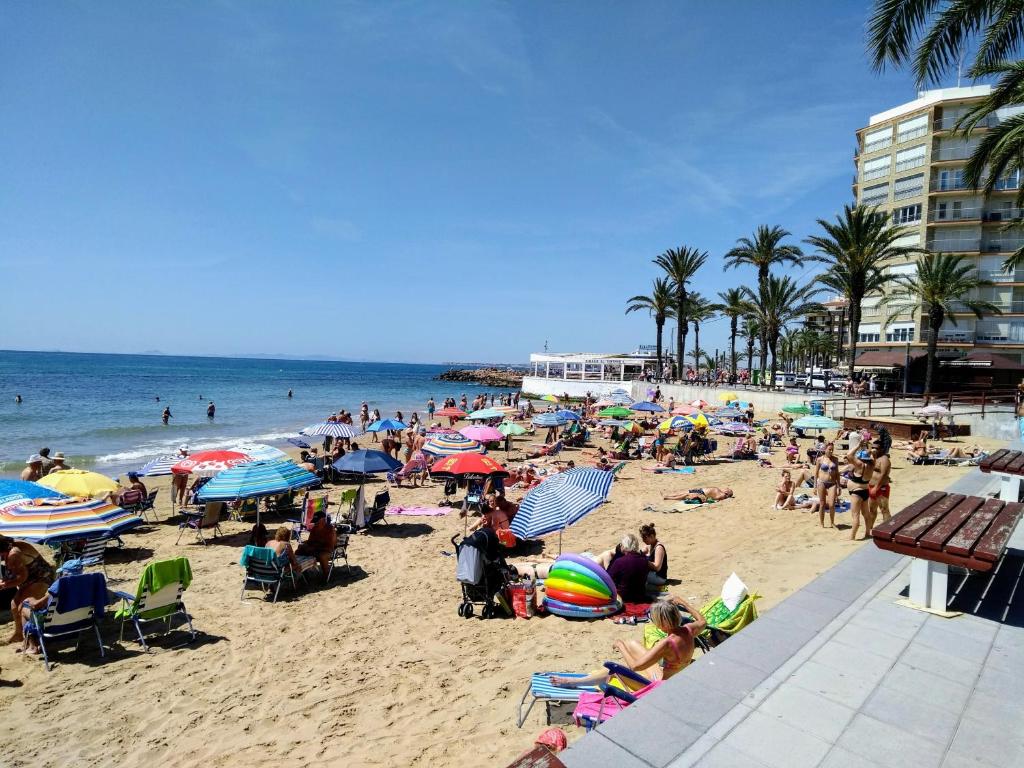 a crowd of people on a beach with the ocean at Apartament Goleta in Torrevieja