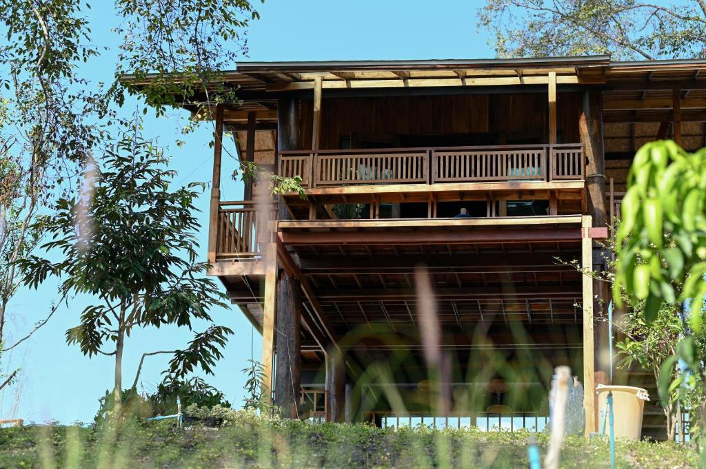 ein Baumhaus mit einer umlaufenden Terrasse in der Unterkunft Pan's farm แบ่งปันฟาร์ม in Ban San Phaya Loei Luang