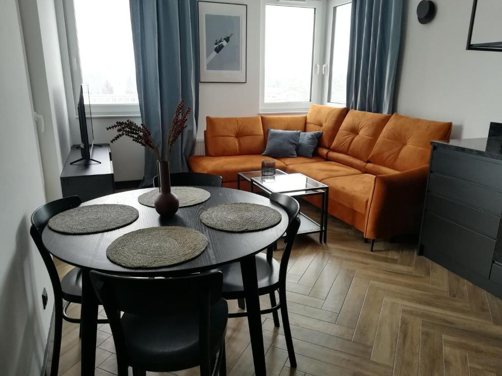 a living room with a table and a couch at Apartament COSY CAVE in Uniejow