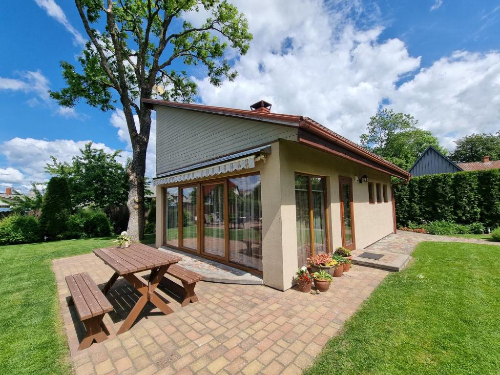a small house with a picnic table in a yard at Saules Street Home in Kuldīga