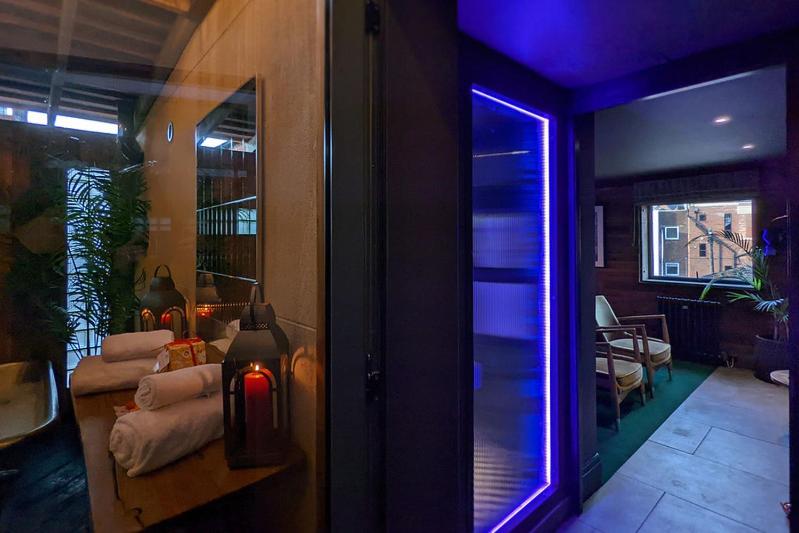 a room with a purple light in a room with a table at The Bells - Luxury Serviced Apartments in Leeds