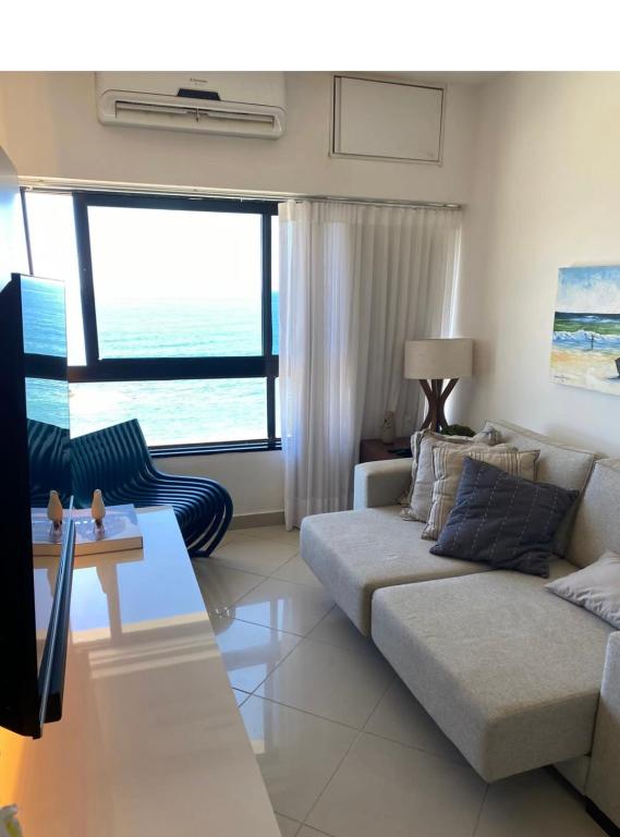 a living room with a couch and a view of the ocean at ONDINA SSA in Salvador