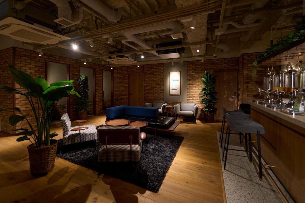 a living room with a couch and a bar at Hotel Resol Stay Akihabara in Tokyo