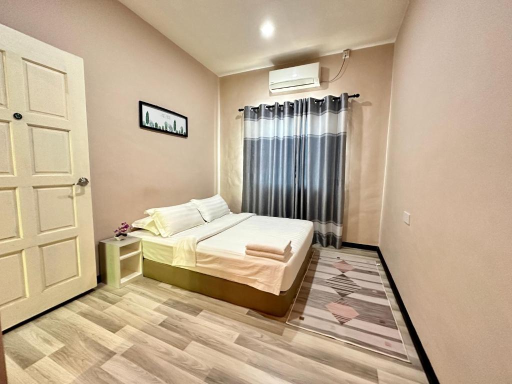 a small bedroom with a bed and a window at ANG LEE HOLIDAY HOME 1 in Semporna