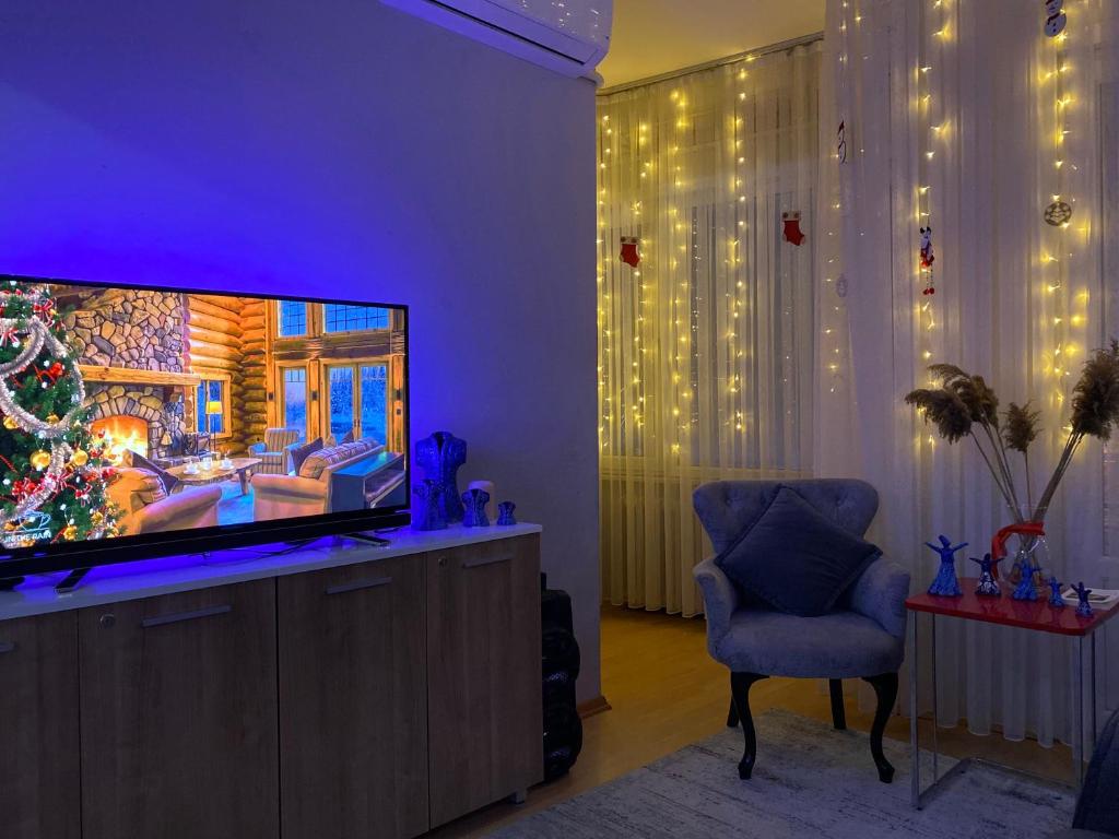 ein Wohnzimmer mit einem TV und einem Weihnachtsbaum in der Unterkunft Kendi evinize hoşgeldiniz in Istanbul
