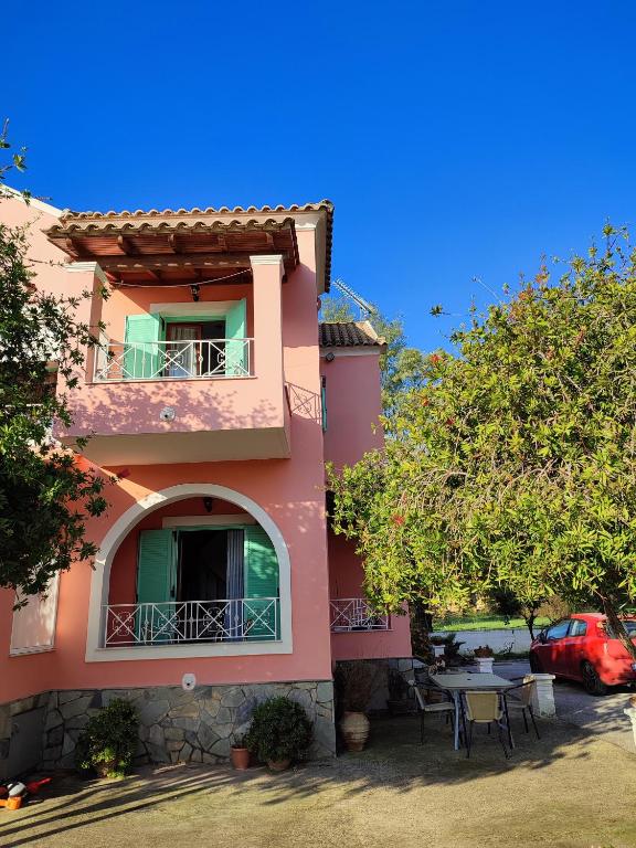 a pink house with a table in front of it at Villa marina apartment2 in Ipsos