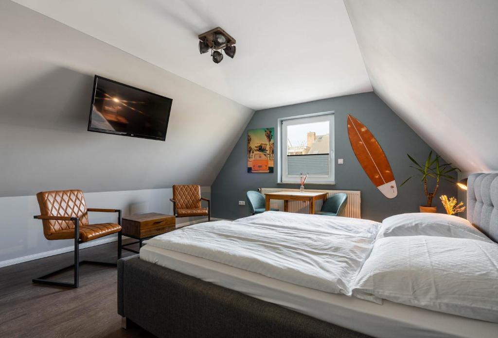 una camera con letto e tavola da surf sul muro di Hotel Luina Beach a Büsum