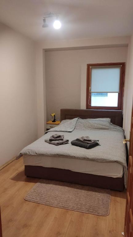 a bedroom with a bed with two towels on it at Stella Apartment in Karaburma