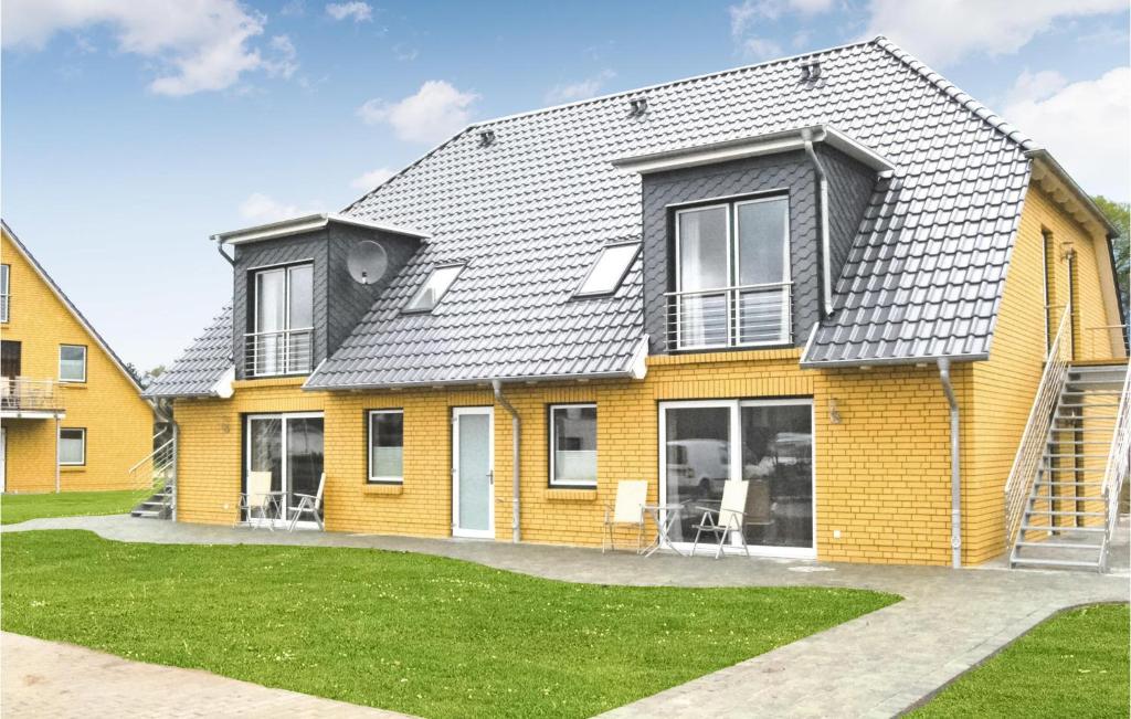 una casa amarilla con techo gris en Fewo Burg Stargard, en Kaschow