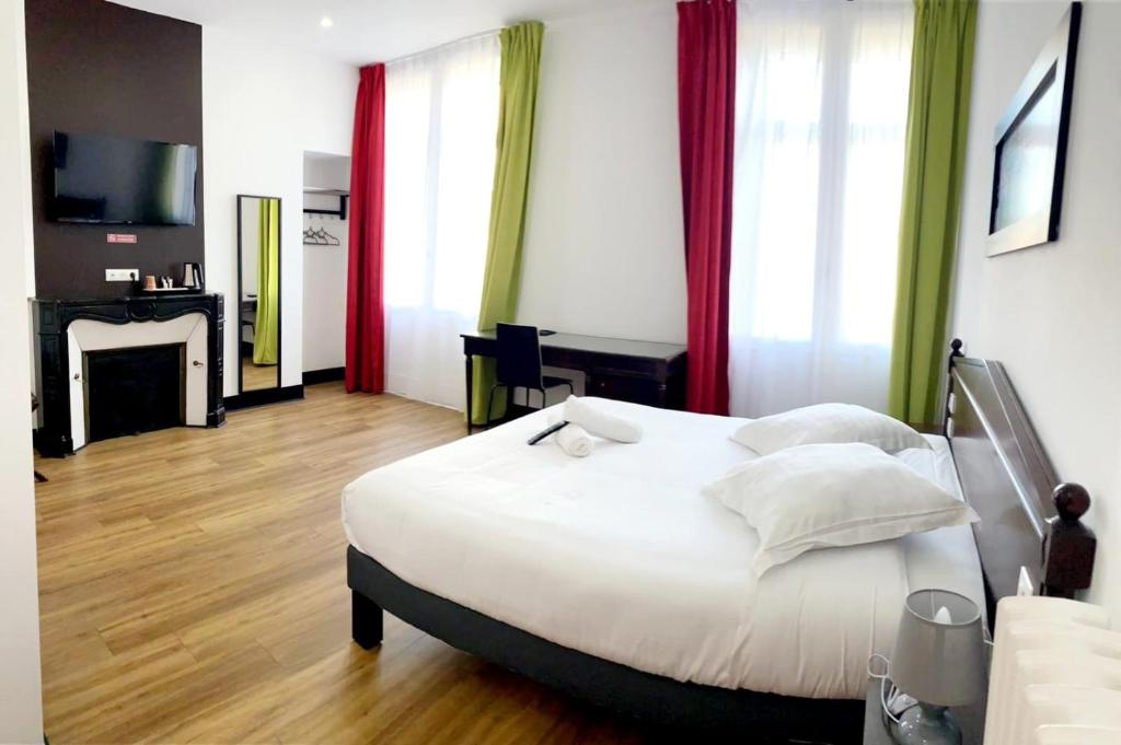 um quarto com uma grande cama branca com cortinas vermelhas em Enzo Hotels Limoges Centre Jourdan by Kyriad Direct em Limoges