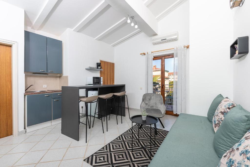 een woonkamer met een bank en een keuken bij Apartman Tea in Novigrad Istria