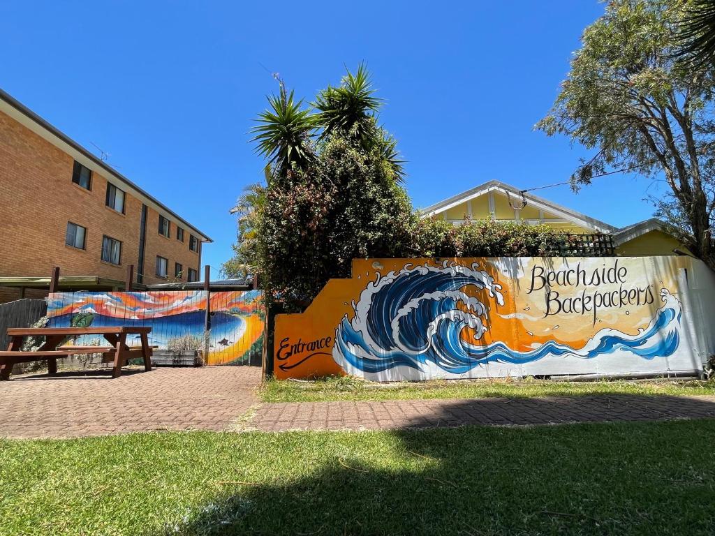 un mur avec une peinture d'une vague sur lui dans l'établissement Beachside Backpackers, à Port Macquarie