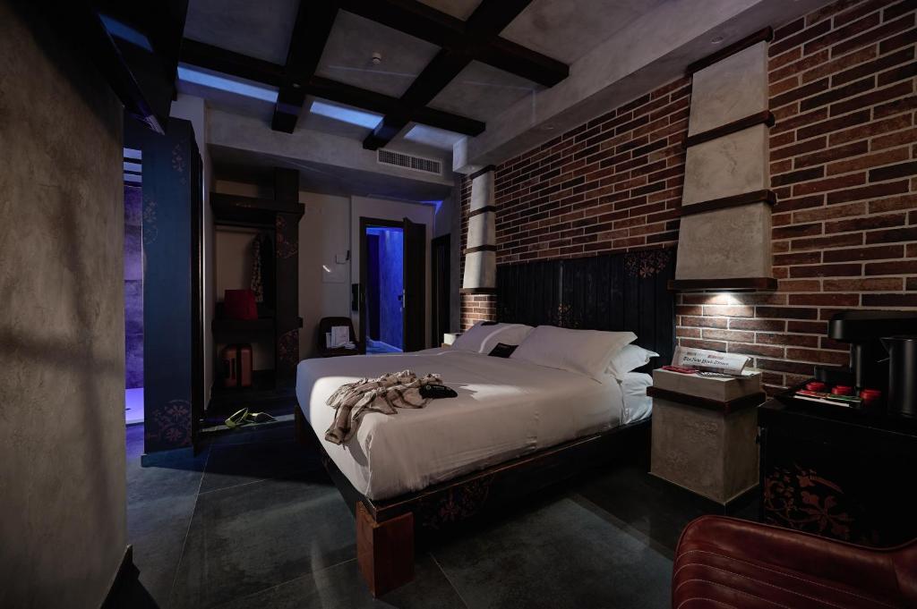 a bedroom with a bed and a brick wall at Mamaco I Teatro Rooms in Foggia
