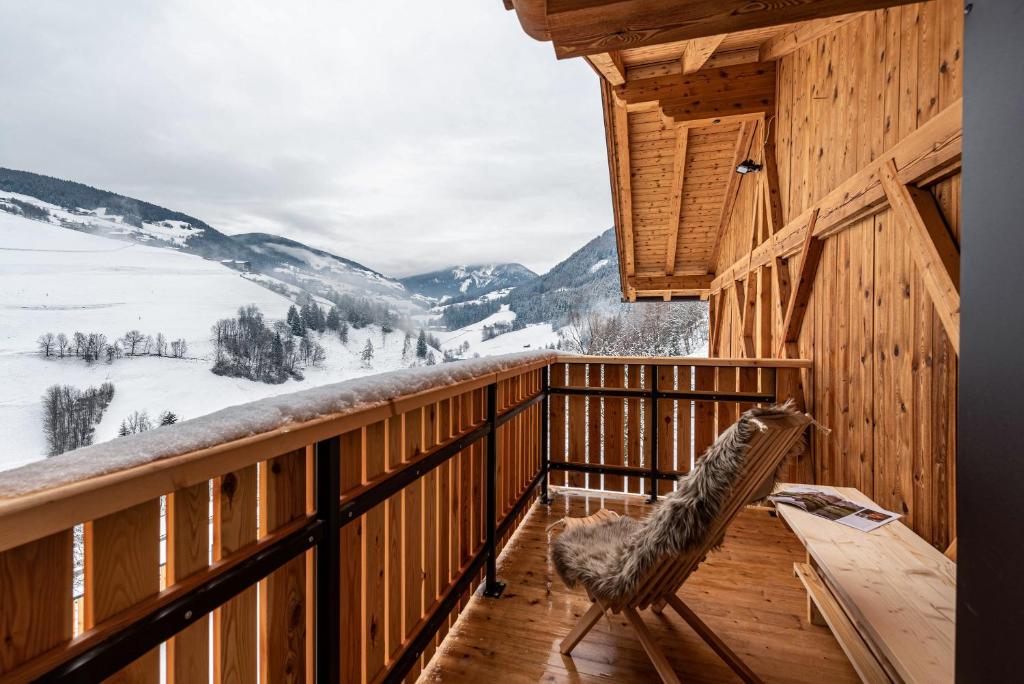 a room with a balcony with a view of the mountains at Planerhof Apartment Alpenrose in Funes