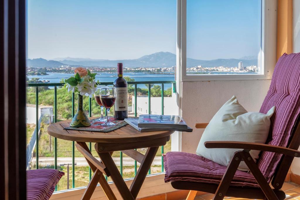 奧爾比亞的住宿－Top floor gulf view apartment，一张桌子,上面放着一瓶葡萄酒和一杯