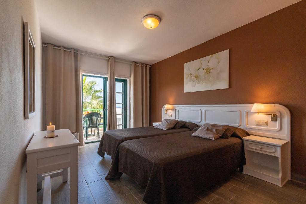 A bed or beds in a room at Aparthotel Neptuno Costadeje