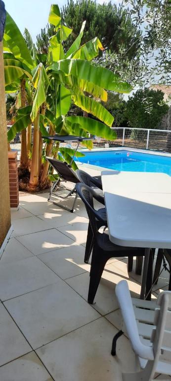 - une rangée de tables et de chaises à côté de la piscine dans l'établissement Villa Beausoleil, à Orban