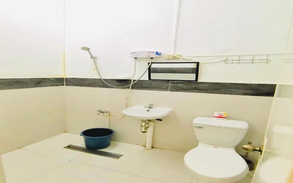 a bathroom with a toilet and a sink at Big Paul Hostel in El Nido
