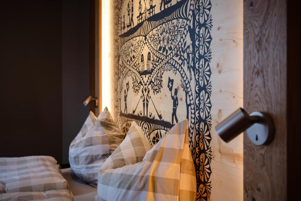 łóżko z czarno-białym zagłówkiem i poduszkami w obiekcie Panorama Hotel & Restaurant w mieście Bettmeralp