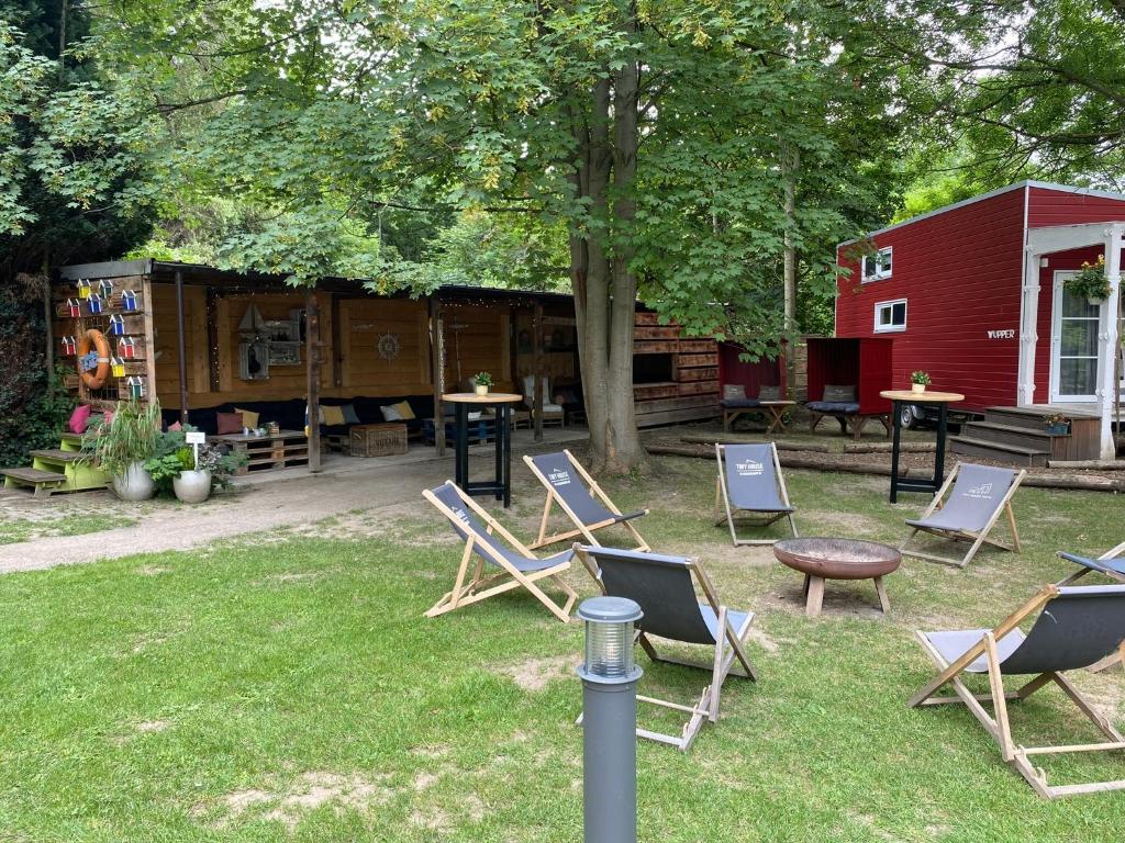 a group of chairs and a table and a house at Tiny House Werse im PIER9 Tiny House Hotel in Hamm