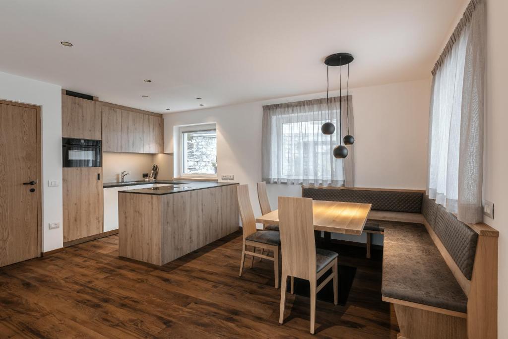 a kitchen and dining room with a table and chairs at Alpenrose Alpine Living in Selva