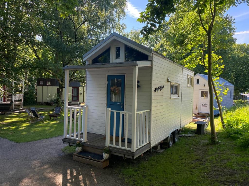 ein winziges Haus, das auf einem Wohnwagen im Hof sitzt in der Unterkunft Tiny House Ems im PIER9 Tiny House Hotel in Hamm