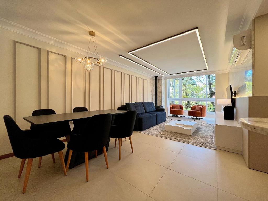comedor y sala de estar con mesa y sillas en Apartamento Solar do Ipê Centro 2 dorm by Achei, en Canela