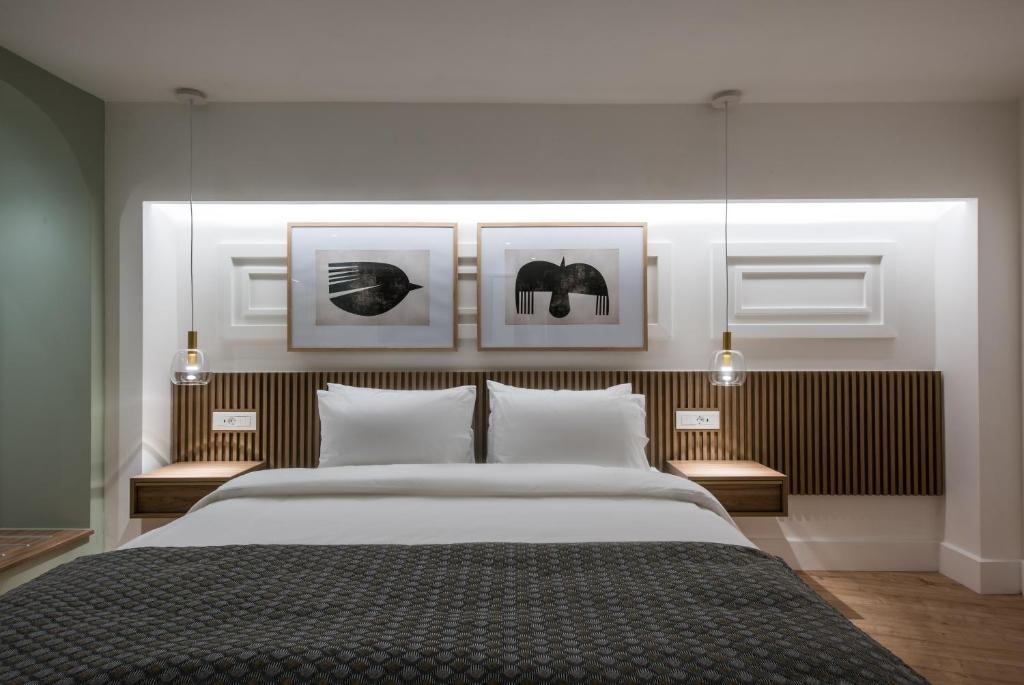 a bedroom with a large bed with three pictures on the wall at The Blossom Collection in Heraklion City Center in Heraklio Town