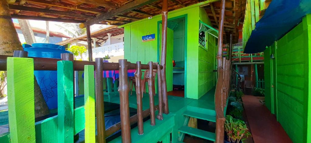 une maison verte et colorée avec une clôture dans l'établissement luna beach home & cabanas, à Galle