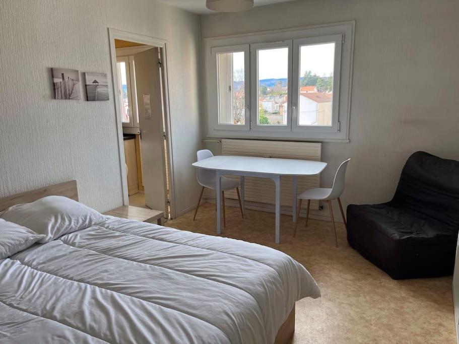 een slaapkamer met een bed, een tafel en een raam bij Le Studio: Agréable logement in Riorges
